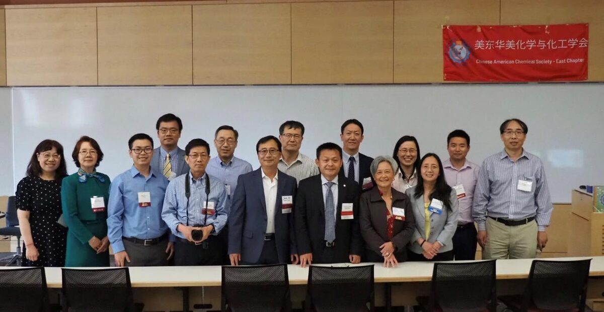 E-CACS Executive Committee, speakers, and supporters posing in front of the society's red banner at the symposium