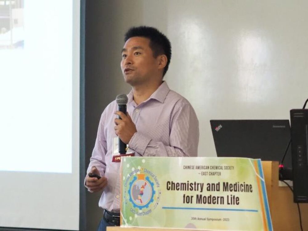 Dr. Yajun Yan presenting on microbial systems for green manufacturing at the symposium podium