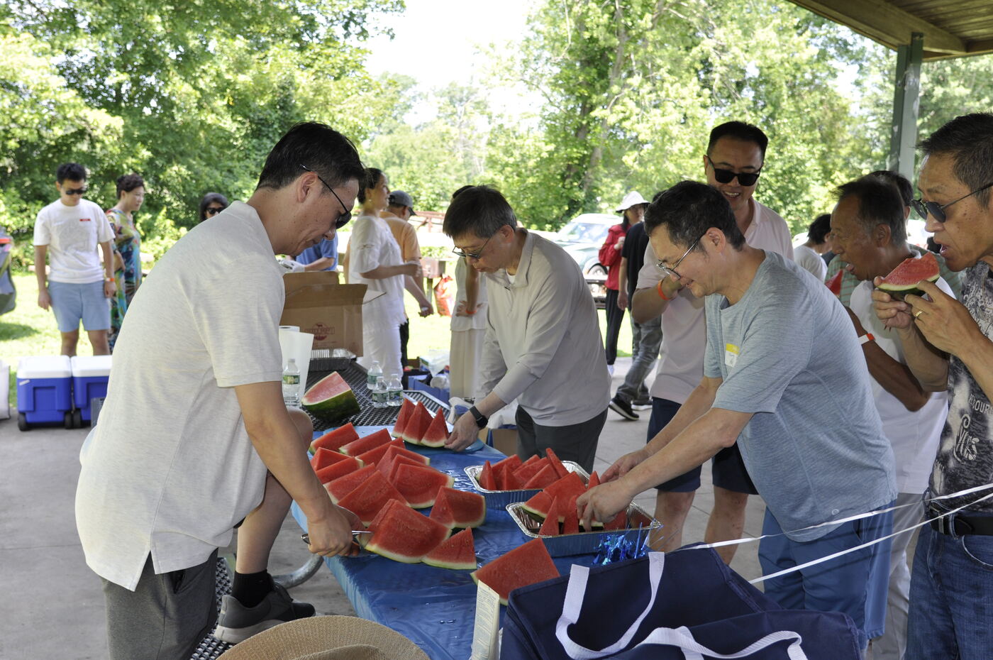 Volunteers unpacking crates of food beside the grill.