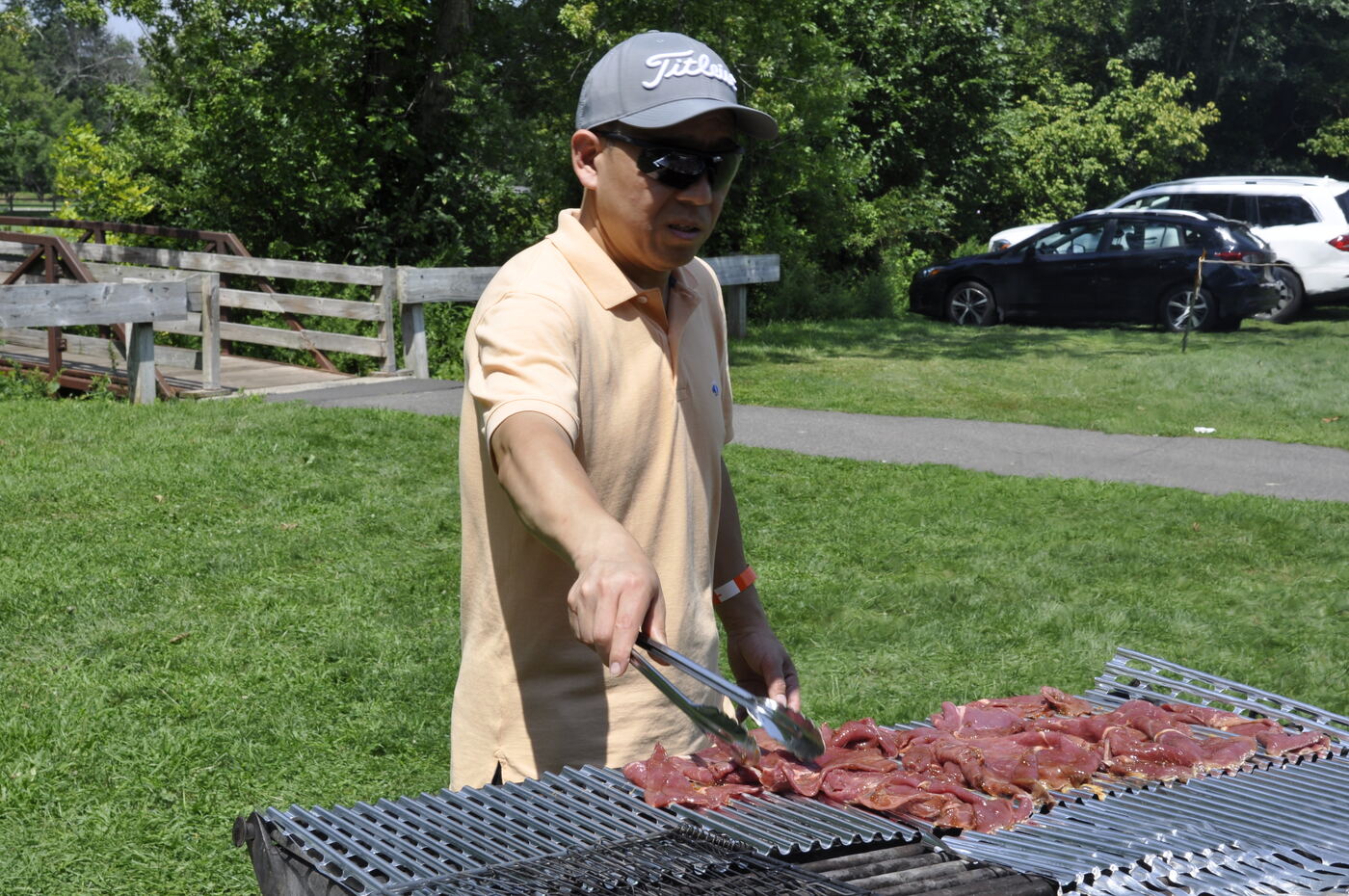 A volunteer grilling meat over the charcoal grill.