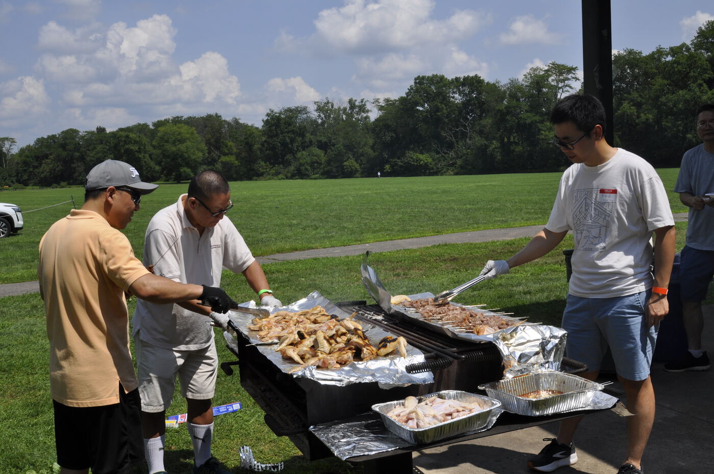 Volunteers serving trays of freshly grilled food.