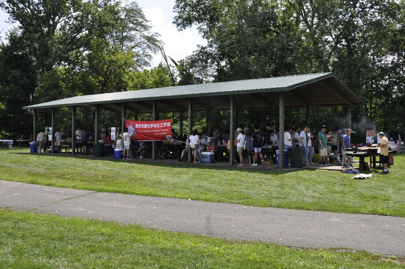 Wide view of the pavilion and the picnic crowd from the lawn.