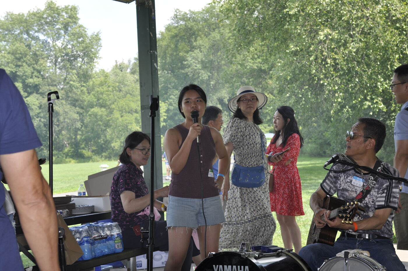 A singer at the microphone accompanied by a guitarist at the pavilion.