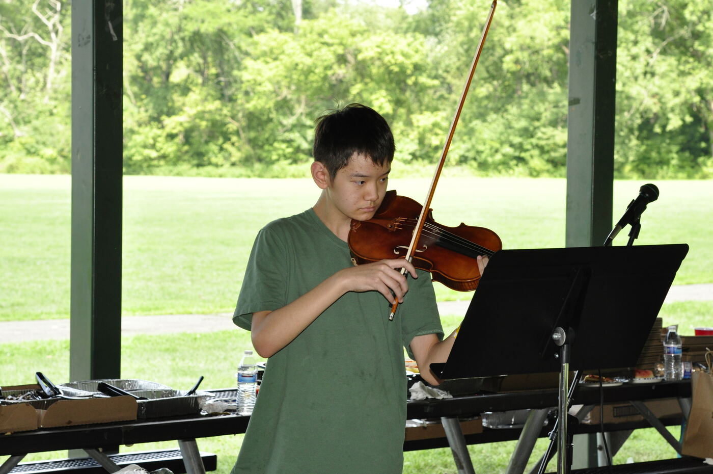 A young musician playing the violin at the pavilion.