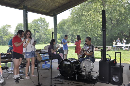 Two young performers singing a duet with the band behind them.